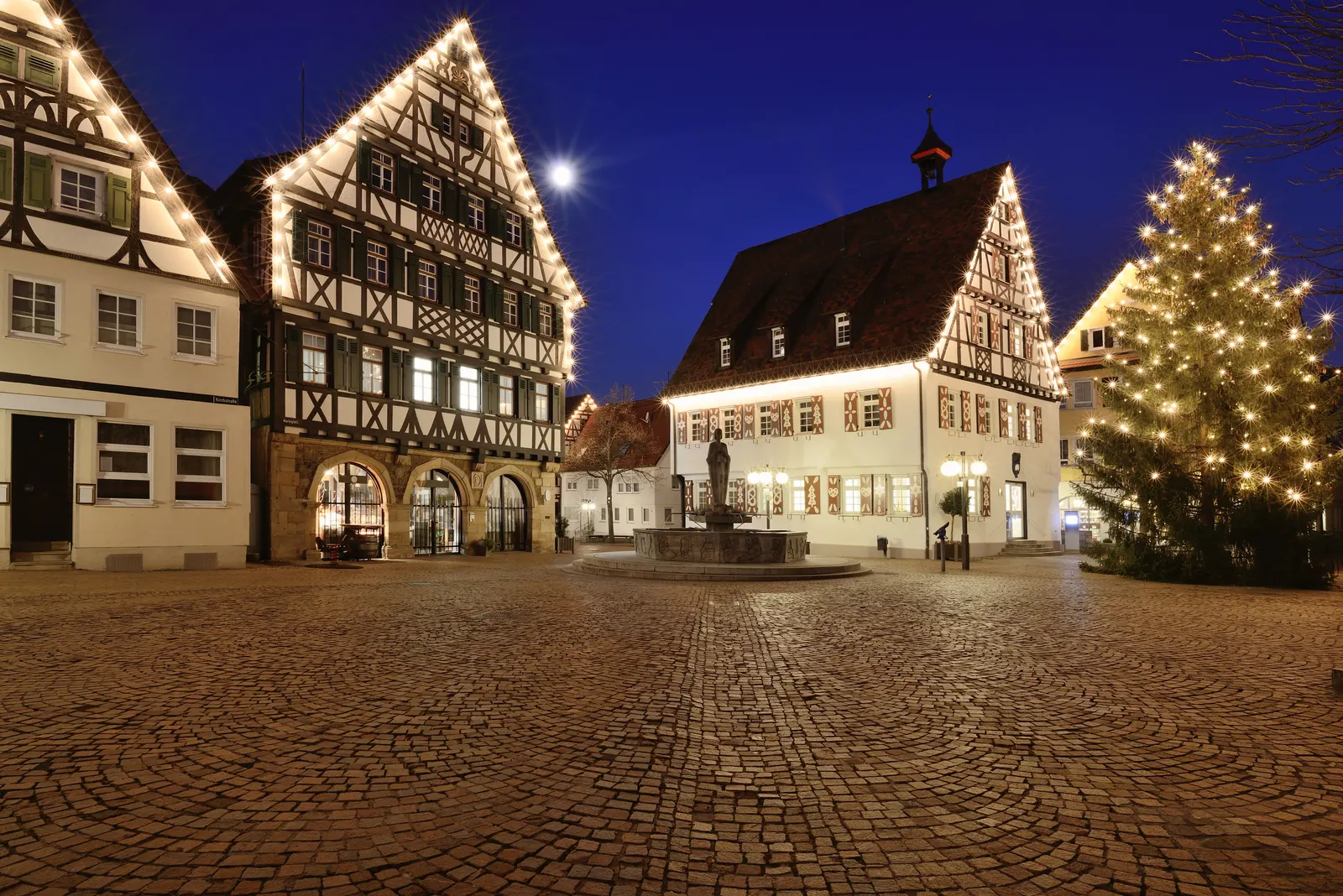 Marktplatz Pfullingen am Abend mit Fachwerkhäusern, Rathaus und Brunnen